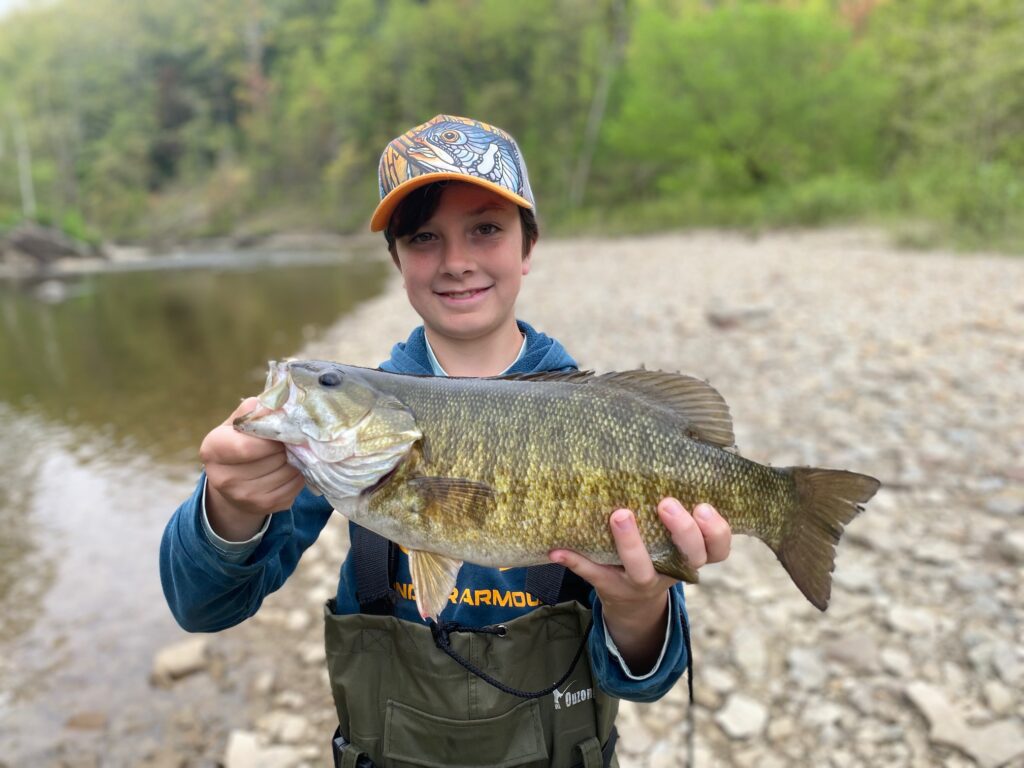 guided client hokding a large lake erie lake run smallmouth bass caught on elk creek near erie pennsylvania on guided trip with keystone anglers guide service