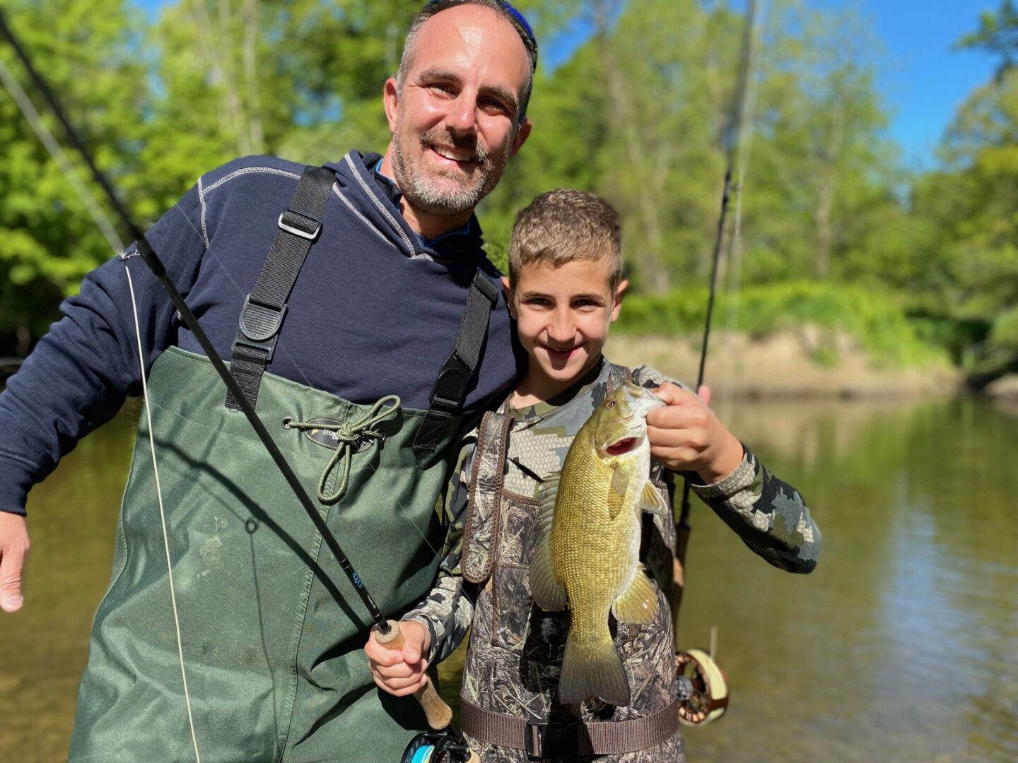 guided clients hokding a large laker erie lake run smallmouth bass caught on fly with keystone anglers guide service in erie pennsylvania on elk creek